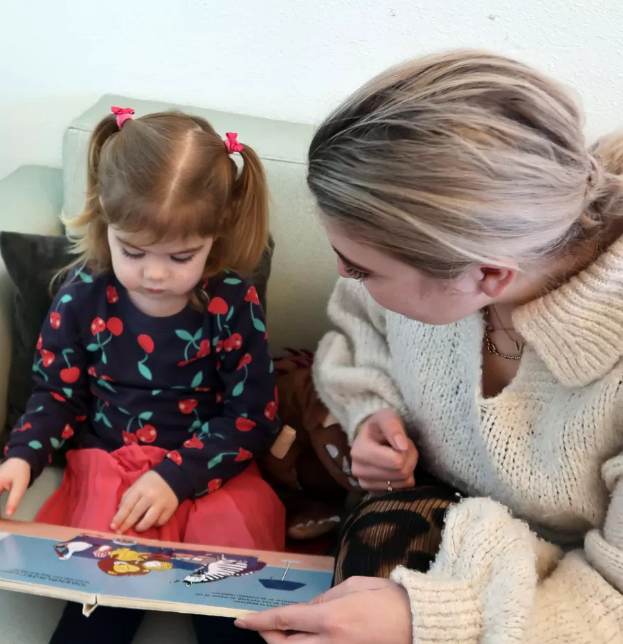 pedagogisch medewerkster leest meisje voor