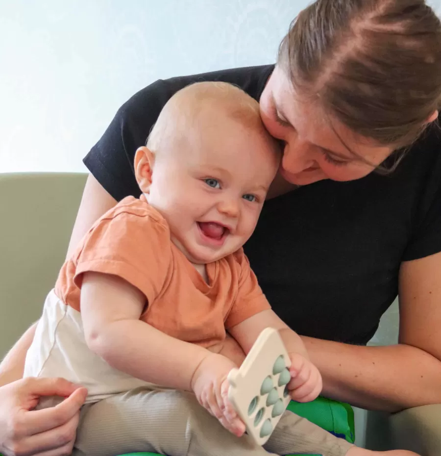 Pedagogisch medewerkster met baby op schoot