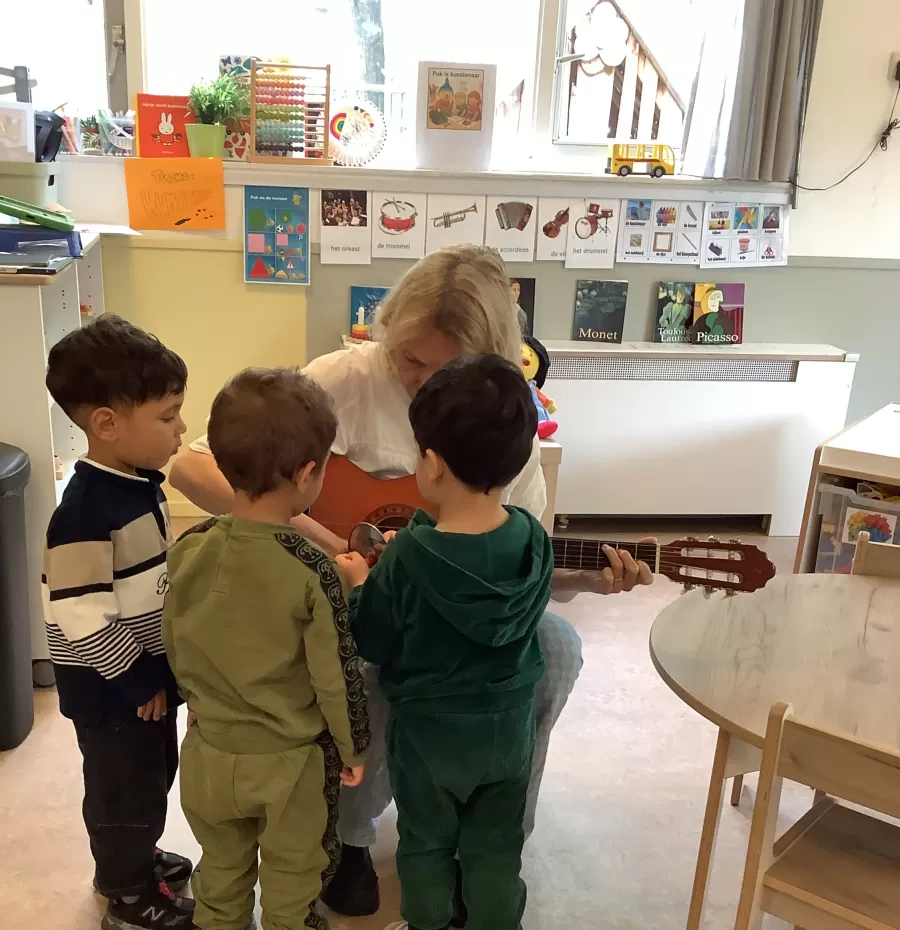 Ilonka speelt op de gitaar met peuterspeelzaal kinderen